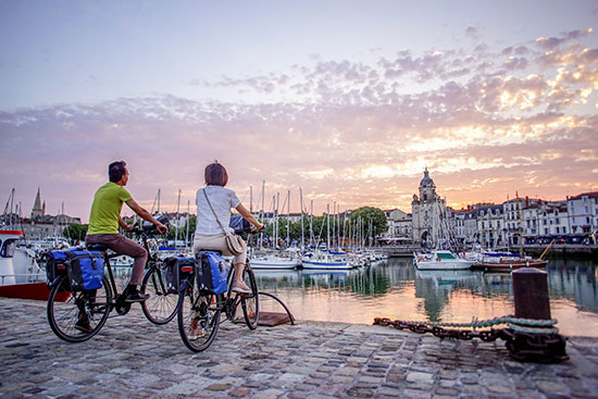 Zwei Radfahrer genießen den Sonnenuntergang in La Rochelle